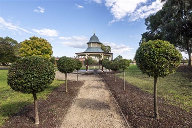 View of Greensborough Rotunda down the end of the manicured tree lined path