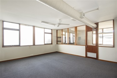 Meeting room looking towards glass wall of the seperate office area