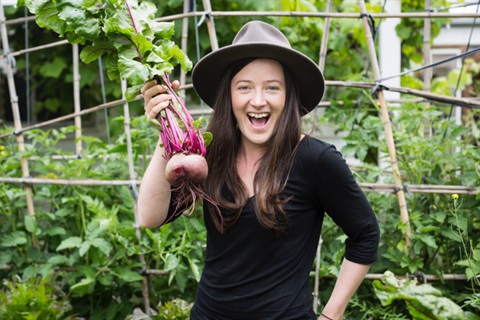 Woman holding a beet in a garden