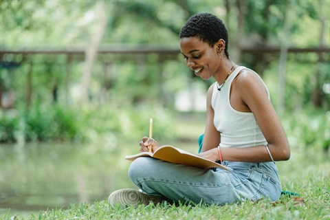 Woman sketching on a lawn